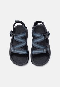 Ζευγάρι εξωτερικών σανδαλιών σε μαύρο και σκούρο μπλε χρώμα με ρυθμιζόμενα λουριά και υφασμένες σόλες, εμφανιζόμενα από πάνω σε λευκό φόντο.