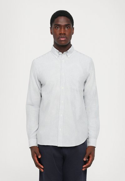 Camicia a righe di colore azzurro chiaro e bianco, realizzata in misto cotone, maniche lunghe, colletto a punta e taschino singolo sul petto.
