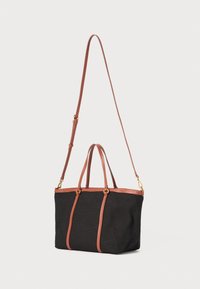 Črna platnena torba z rjavimi usnjenimi detajli in trakovi. Ima dve zgornji ročki in odstranljiv ramenski trak.