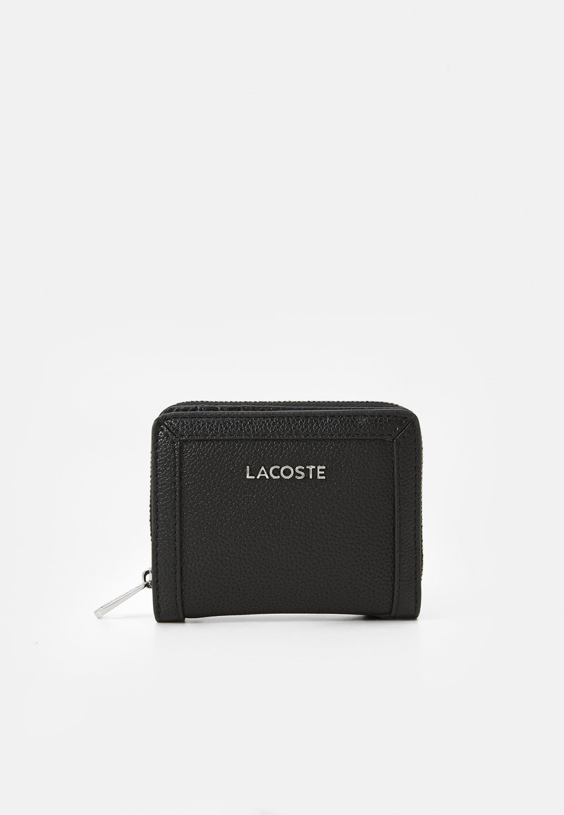 Svart lærpung med teksturert finish, med glidelås og en sølvfarget "LACOSTE"-logo preget på forsiden.