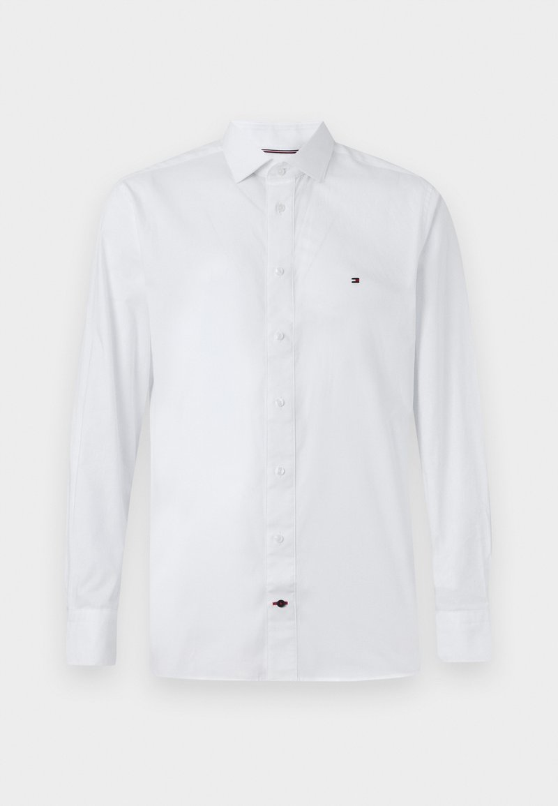 Chemise blanche à manches longues, boutonnée, en tissu lisse, dotée d'un col classique et d'un petit logo multicolore brodé sur la poitrine.