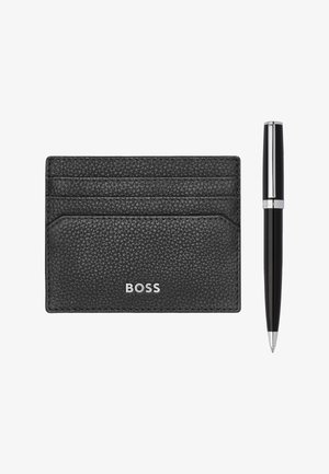 Sort tekstureret læderkortholder med tre kortlommer og sølv "BOSS"-logo ved siden af en slank sort kuglepen med sølv accenter.