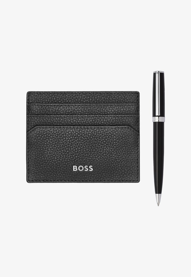 Porte-cartes en cuir noir texturé avec trois emplacements pour cartes et logo argenté "BOSS" à côté d'un stylo bille noir fin avec des accents argentés.