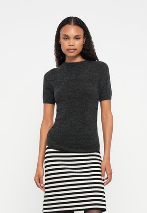 Maglione aderente a maniche corte di colore grigio scuro con scollo rotondo e texture liscia, abbinato a una gonna a righe bianca e nera.