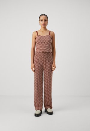 Ensemble deux pièces composé d'un haut court à motifs marron et crème avec des bretelles fines, associé à un pantalon large assorti arborant un design similaire.