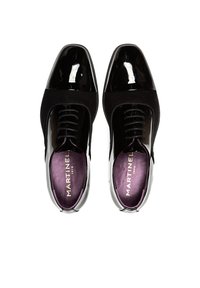 Zapatos de charol negro con parte superior texturizada, punteras redondeadas y plantillas moradas que presentan la marca "MARTINEL" en dorado.