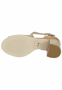 Beige high-heeled sandal with a textured sole, adjustable ankle strap, and smooth upper material; features a short, block heel.