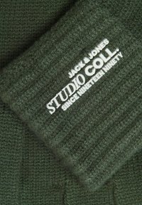 Grøn strikket beanie med ribbet struktur, hvor hvid logo tekst "JACK & JONES STUDIO COLL. SINCE NINETEEN NINETY" står fremtrædende.