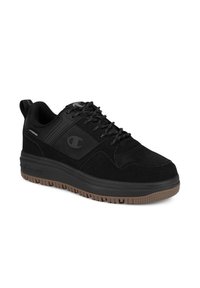 Scarpe sportive nere realizzate in materiali scamosciati e in rete, con punta rotonda, design con lacci e suola in gomma testurizzata marrone. Presentano un logo sul lato.