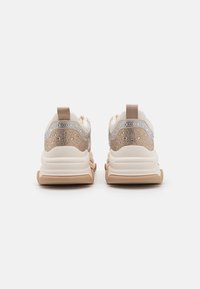 Sneakers in beige with a textured backing featuring transparent rhinestones and subtle blue accents. Cushioned soles and rear pull tabs.