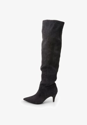 Black suede over-the-knee boots with a pointed toe and a low kitten heel. Features a slouchy design and stitching along the side.