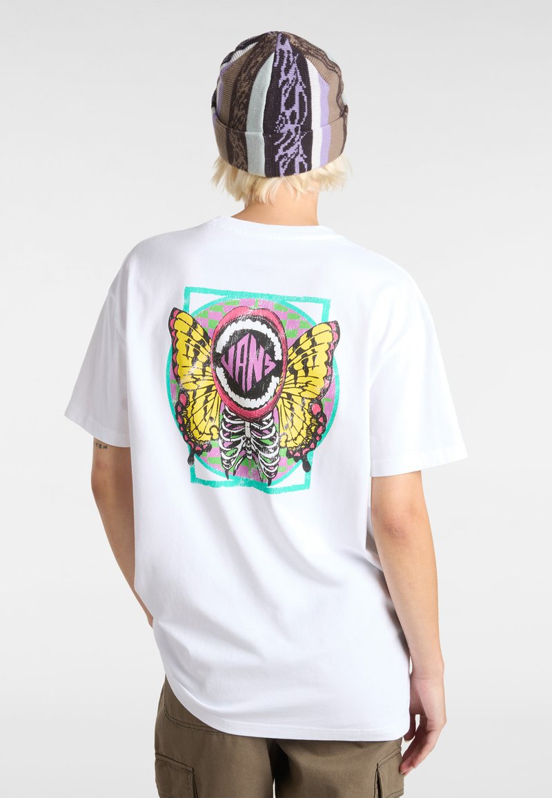 Witte katoenen t-shirt met een kleurrijke vlinderafbeelding en een cirkelvormig logo op de achterkant, tegen een geometrisch ontwerp.