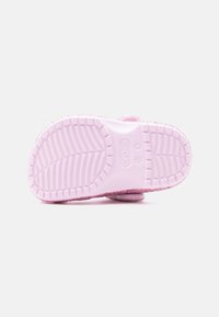 Ροζ Crocs με υφή στην εξωτερική σόλα, με σχέδιο στο κάτω μέρος και μαλακό, χνουδωτό πάνω μέρος. Κλειστή πίσω πλευρά με  ρυθμιζόμενο λουρί για άνεση.