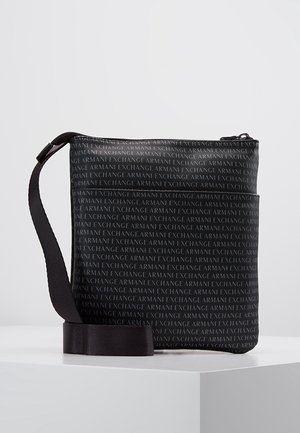 Sort rektangulær crossbody taske med gentaget "ARMANI EXCHANGE" tekstmønster og justerbar rem, hvilende på en hvid overflade.