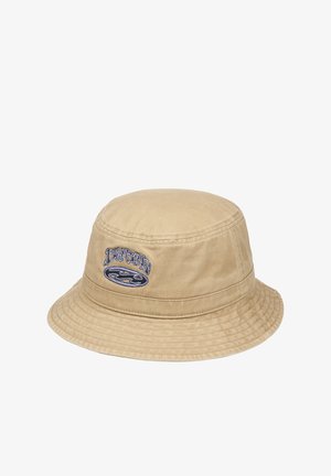 Bež bombažni klobuk z ravno krono, širokim robom in vezenim logotipom. Ima gladko teksturo in subtilne detajle šivov.