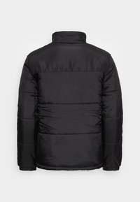 Black puffer jacket with a high collar, quilted design, and elasticized cuffs. Smooth, lightweight fabric featuring horizontal paneling.