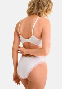 Witte lingerieset met een eenvoudige beha met verstelbare bandjes en een bijpassende hooggerande slip, beiden met delicate kanten afwerking.