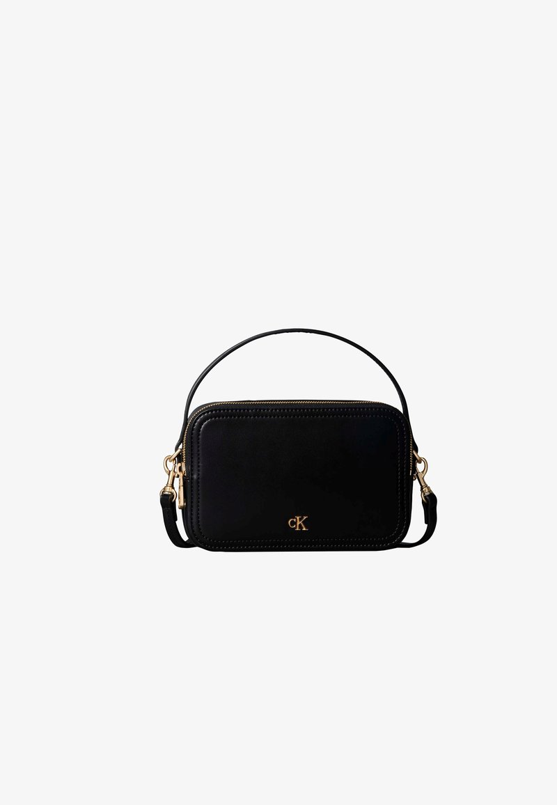 Sac à main rectangulaire noir avec fermeture éclair dorée et petit logo CK doré, doté d'une poignée courte et d'une bandoulière amovible.