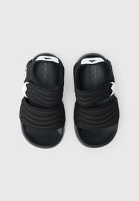 Mustad sandaalid kahe tekstuurse, reguleeritava rihmaga, millel laineline disain ja valged Adidas-logo aktsendid külgedel.