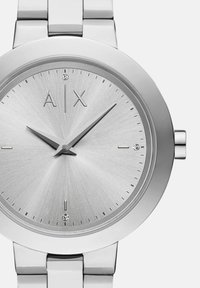 Hõbedane Armani Exchange käekell minimalistliku korraldusega dial'iga, kristallidest tunnikohtadega kell 12, 3 ja 6 ning metallist link-rihm.