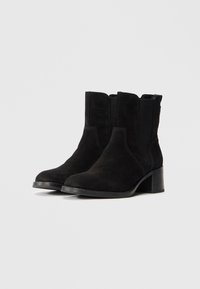 Stivaletti alla caviglia in suede nero con una superficie liscia, dotati di un tacco basso a blocco e pannelli laterali elastici per una facile calzata.