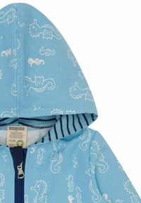 Blaue Kapuzenjacke mit einem weißen Seepferdchenmuster, aus 100% Bio-Baumwolle gefertigt, mit einem gestreiften Innenfutter und einem Frontreißverschluss.