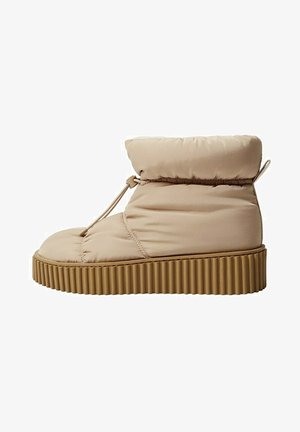 Beige gevoerde enkellaars met een dikke geribbelde rubberen zool en verstelbare aantrekkoordsluiting.