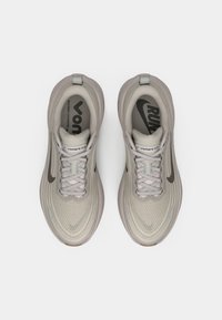 Pair of light gray Nike Vomero Plus running shoes viewed from above on a plain white background.
