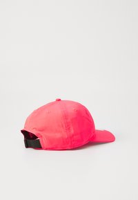 Boné rosa com uma aba curva, feito de um tecido suave, apresentando uma faixa preta ajustável na parte de trás e um pequeno logótipo na lateral.