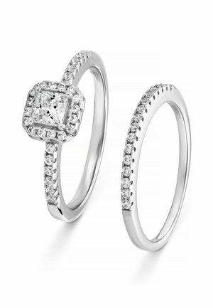 Silberring-Set mit einem quadratisch geschliffenen Centerstein, umgeben von kleineren Steinen, wobei einer der Ringe entlang des Bandes mit Steinen besetzt ist.