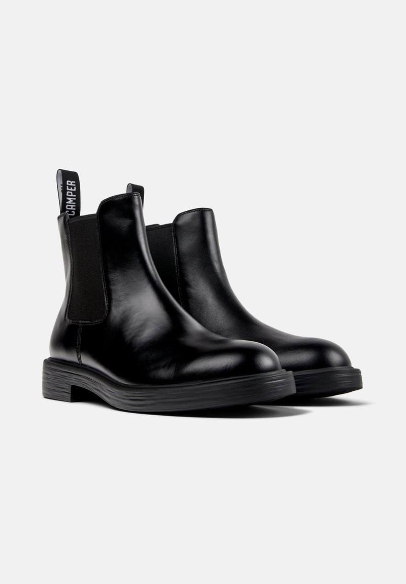 Pair of black leather Chelsea boots with elastic side panels and branded pull tabs, displayed on a plain white background.