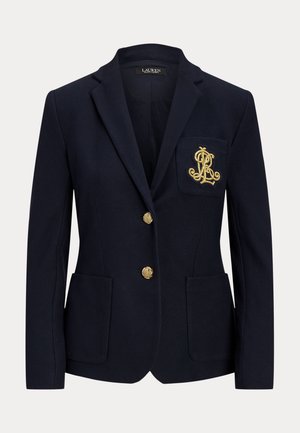 Marineblå blazer med to gullknapper, frontlommer med lapp og brystlomme med et gullbrodert monogram.