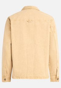Chaqueta de mezclilla beige con mangas largas, un cuello y puños abotonados. Presenta una costura en la yugo centrada en la parte trasera y un detalle de costura mínimo.