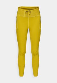 Κίτρινες κολάν με εφαρμοστό σχεδιασμό, ψηλή μέση, κορδόνι, επίπεδες ραφές και πλαϊνή τσέπη. Κατασκευασμένες από ελαστικό, λείο υλικό.