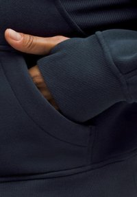 Granatowa bluza z kapturem z prążkowanym mankietem na rękawie, wyposażona w przednią kieszeń i teksturowaną tkaninę, prezentująca gładki i dopasowany krój.