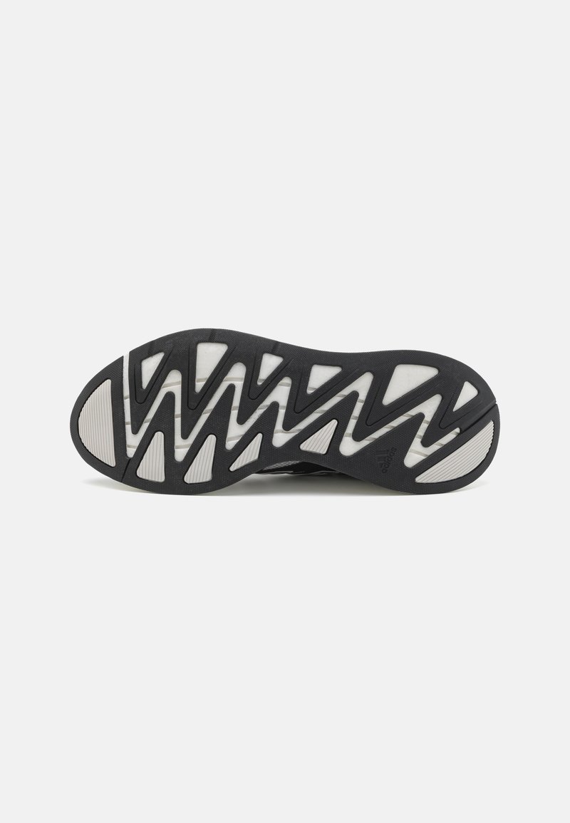 Sole di scarpa da atletica nera realizzata in materiale gommoso testurizzato, con un motivo a zigzag e un design con accento bianco. Punta arrotondata e trazione pronunciata.