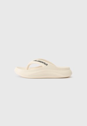 Beige flip-flop szandál ívelt talppal és kiemelkedő szélekkel, fekete "Karl Lagerfeld" logóval a pánton. Simaság jellemzi.