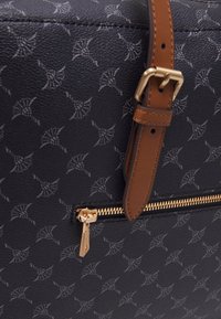 Czarna torebka ze skóry o teksturze z subtelnym, powtarzalnym wzorem. Posiada złoty zamek błyskawiczny i regulowany w kolorze brązowym pasek na ramię.