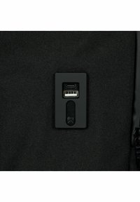 Puerto de carga USB de tela negra texturizada con conexiones USB-C y USB estándar, encerrado en una carcasa rectangular de plástico negro.