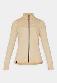 Beige hettejakke med teksturert design, høy krage og svart glidelås. Har oransje detaljer og en tettsittende silhuett.