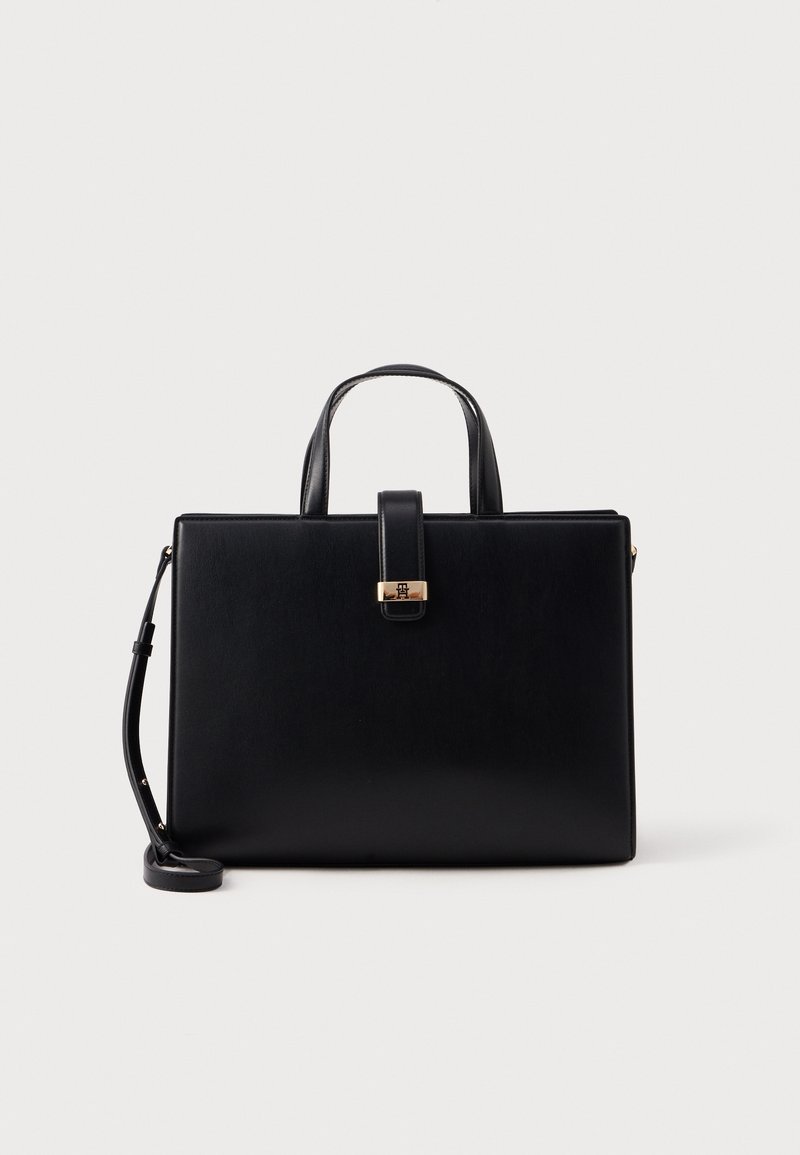 Sac à main rectangulaire en cuir noir avec doubles poignées supérieures, une sangle avant avec fermoir doré et une bandoulière réglable sur fond blanc.