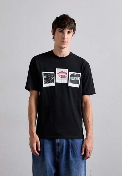 Sort bomuld t-shirt med tre trykte designs: en sikkerhedsnål, røde læber og "MOSCHINO" tekst, alle på hvide firkanter. Casual pasform.