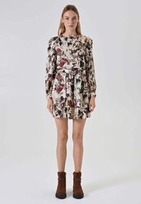 Abito floreale in tessuto leggero con maniche lunghe, scollo rotondo e cintura in vita. Presenta una combinazione di tonalità marrone scuro, beige e verde.