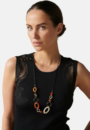 Top de punto negro con relieve que presenta intrincados detalles de encaje en los hombros, combinado con un collar de cuentas multicolores de diversas formas y tamaños.