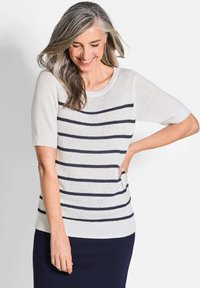 Lichte gebreide trui in crème met marineblauwe strepen, korte mouwen en een brede halslijn; zachte textuur en een relaxte pasvorm.