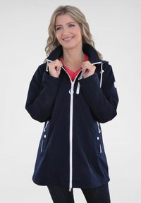 Marineblauer wasserdichter Jacke mit weißem Reißverschluss, verstellbarem Kapuze und Seitentaschen. Hat eine lockere Passform und eine glatte Stoffoberfläche.