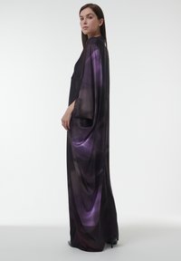 Lange, vloeiende jurk in donkerpaars en zwarte satijn met een gradientpatroon. Heeft wijde mouwen en een losse pasvorm, ontworpen voor comfort.