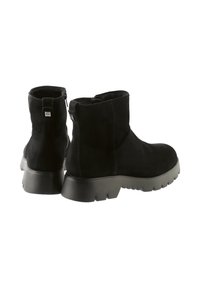 Schwarze Wildleder-Stiefeletten mit einer kräftigen schwarzen Gummisohle, ausgestattet mit einem seitlichen Reißverschluss und einem dezenten Logo-Detail auf der Rückseite.