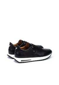 Zwarte leren sneakers met een stijlvolle uitstraling, voorzien van een witte buitenzool, ronde veters en een bruine binnenkant. Discreet logo op de hiel.