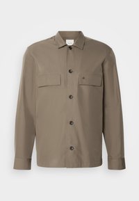 Brown button-up shirt with two chest pockets, black buttons, and a small logo on the left pocket. Made from a smooth fabric with a structured fit.